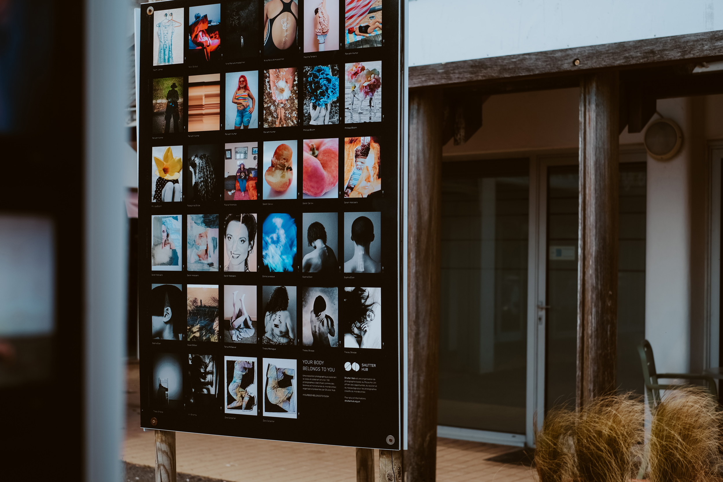 photograph of an exhibition panel board displaying portrait photographs in an outside space