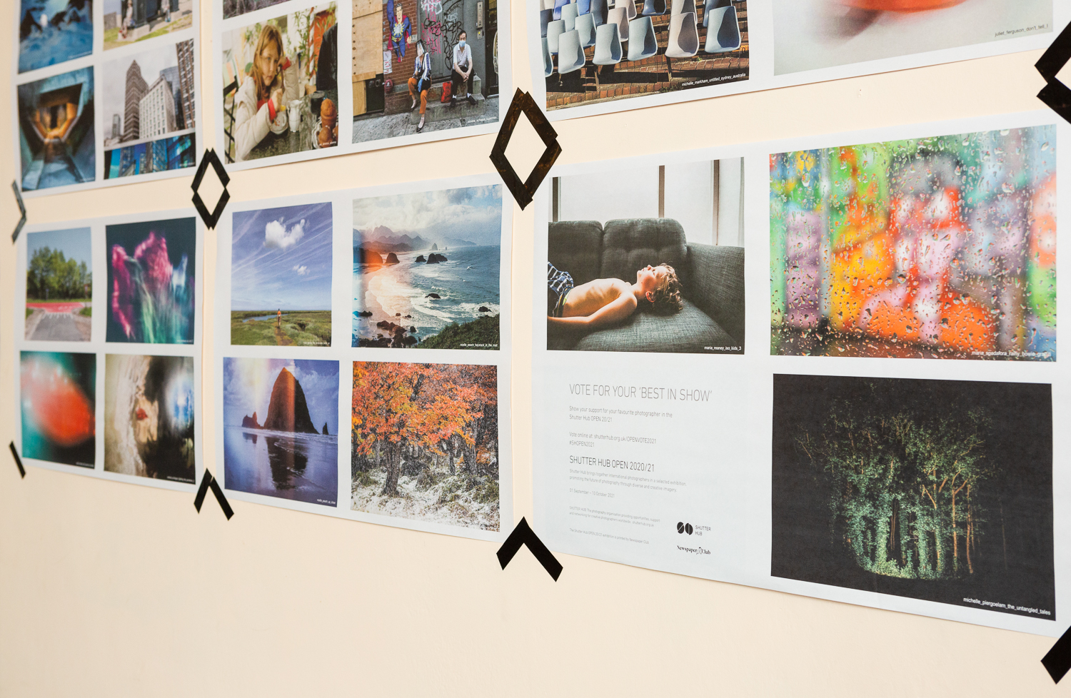 Photograph in the Gallery Café at St. Margaret's House, showing an exhibition of photographs printed on newsprint.