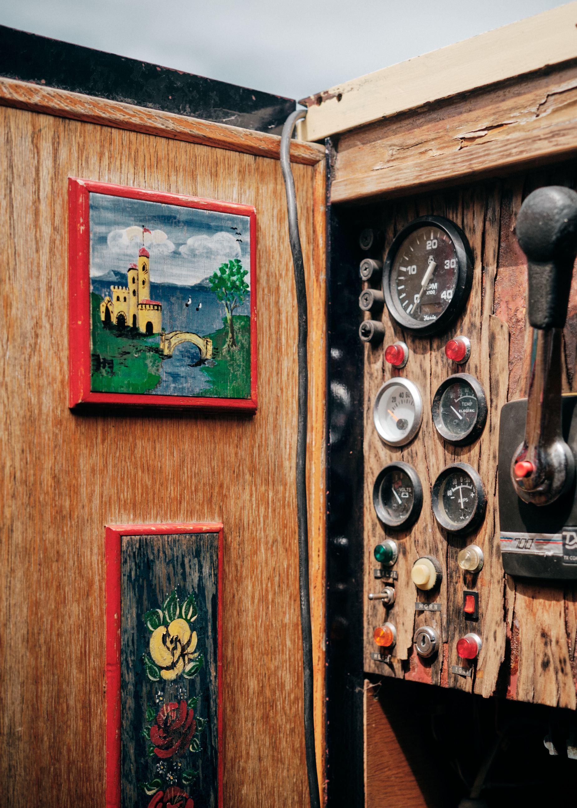 photograph of a door, with roses and castles painted on them. next to it is a instrument board with dials and buttons
